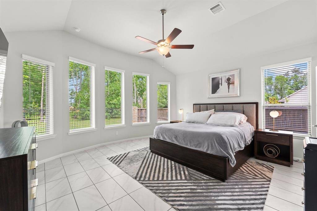 Primary bedroom boasts a lot of natural light coming through these 6 large windows.