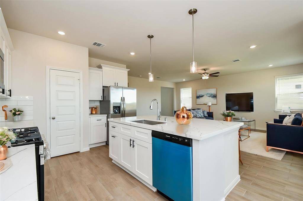 Notice the elegant countertops and the pendent lights that hang above the island counter.