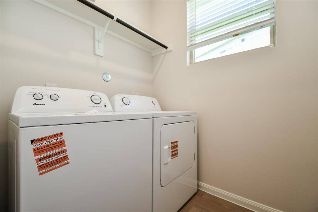 The utility room with a built-in shelf is perfect for storage needs in this laundry room.