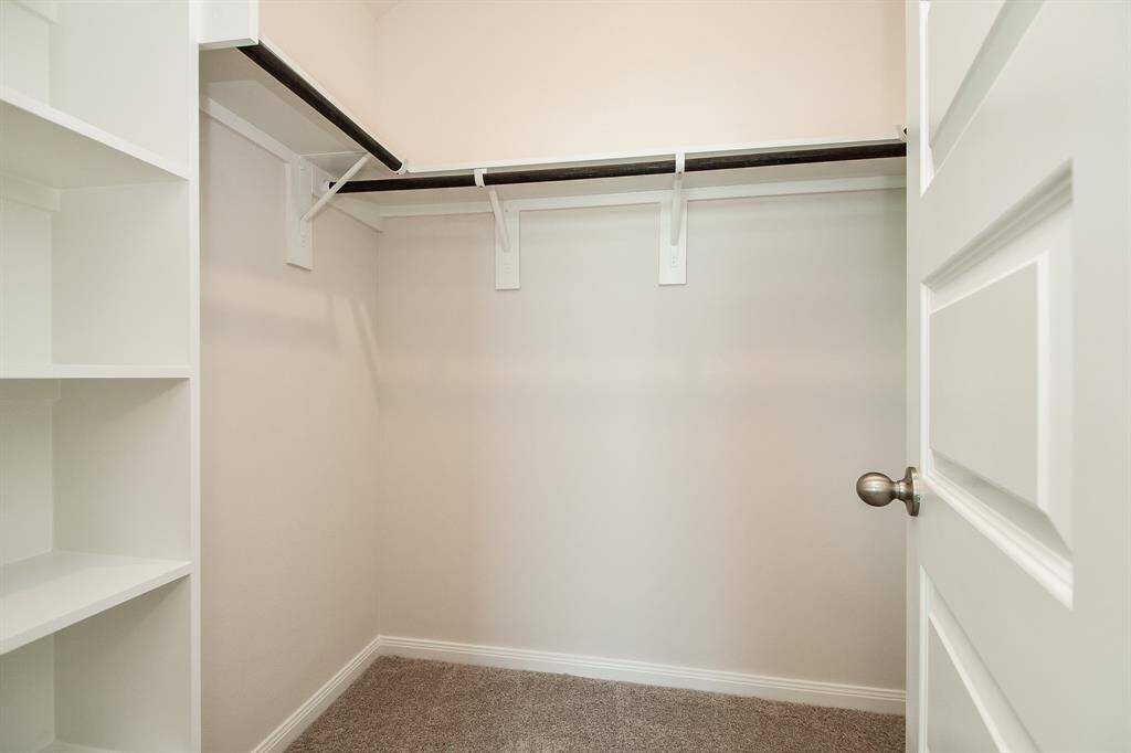 Step into this spacious closet with built-in shelving, making organizing a breeze.