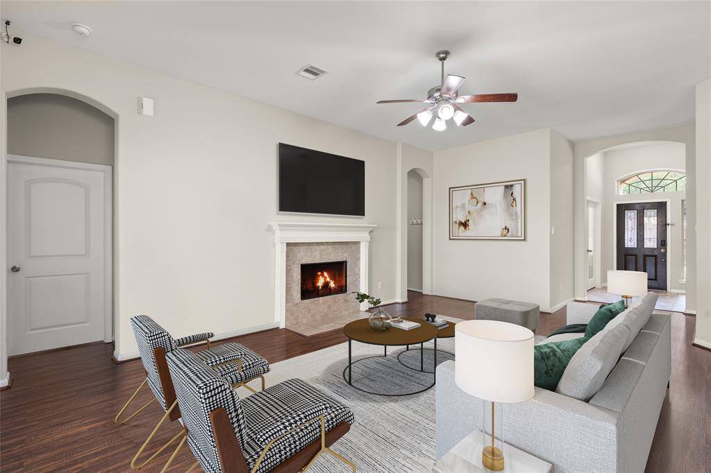 The living room, featuring a cozy fireplace and sleek laminate flooring, offers a bright and inviting space for relaxation and gatherings.