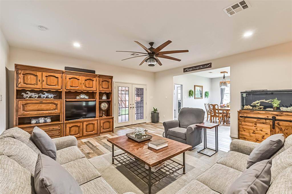 The living room has French doors that open to a back covered patio