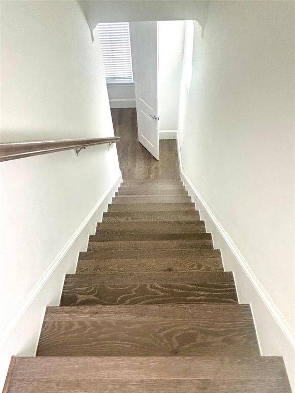 Stairs down from 3rd floor to 2nd floor; lots of natural light at the top and the bottom of stairs