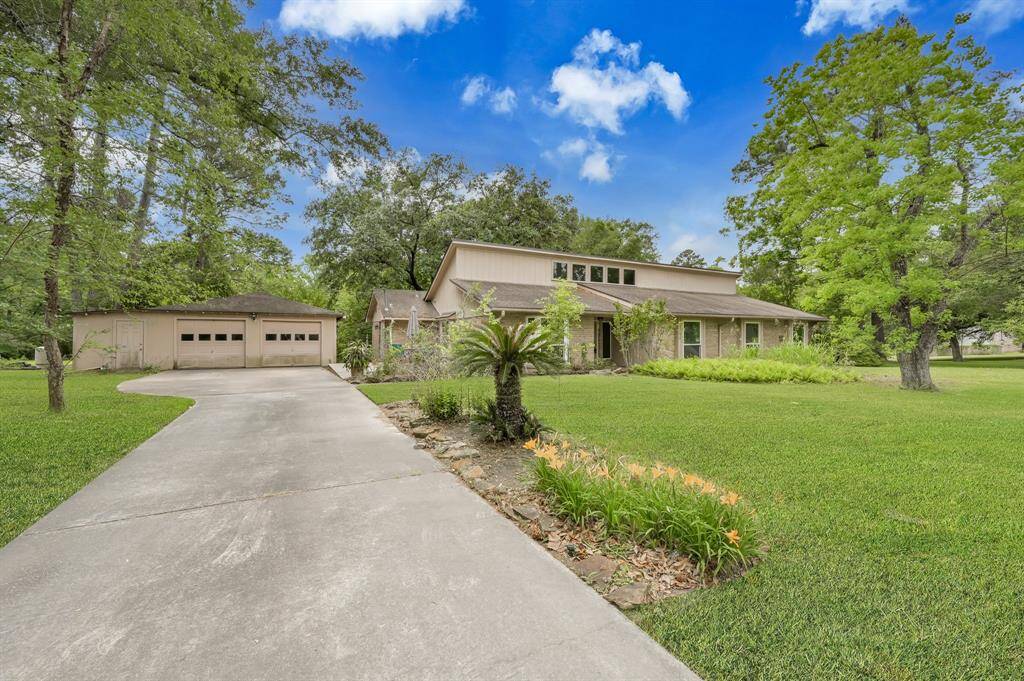 Long driveway leading to the 2 car garage with extra storage and side entrance to home.