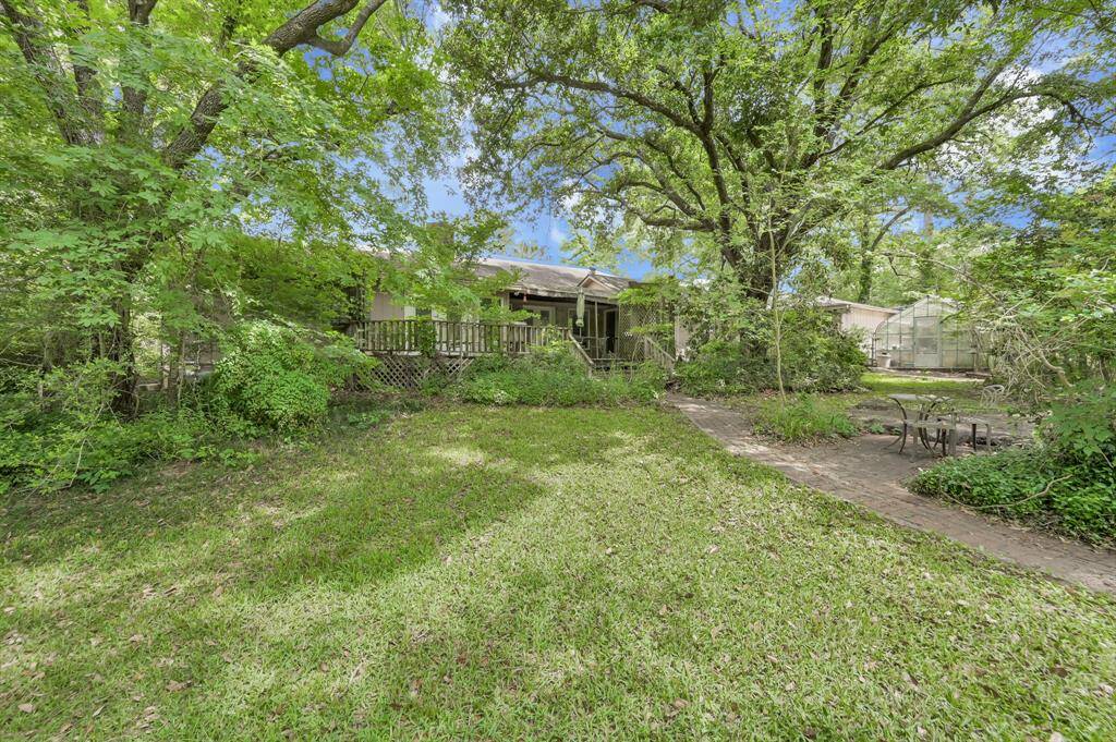 View from side of property looking to house. In the background behind the garage you can see there is a greenhouse.