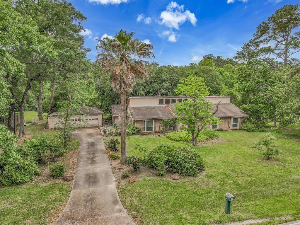 Ariel view of front of home with mature trees and side deck.