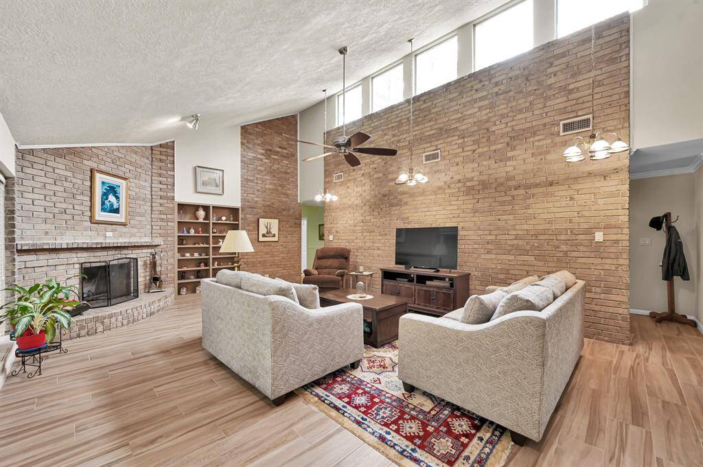 Large den with wood burning fireplace, built in shelves and plenty of natural light.