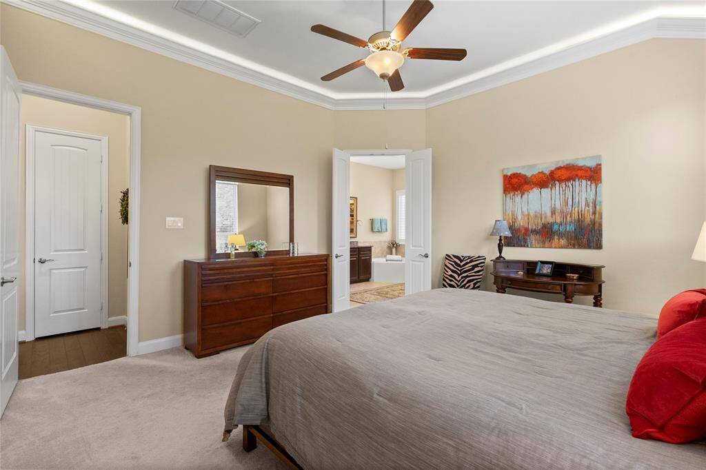 Elegant primary bedroom with ensuite bathroom, featuring warm, neutral tones.