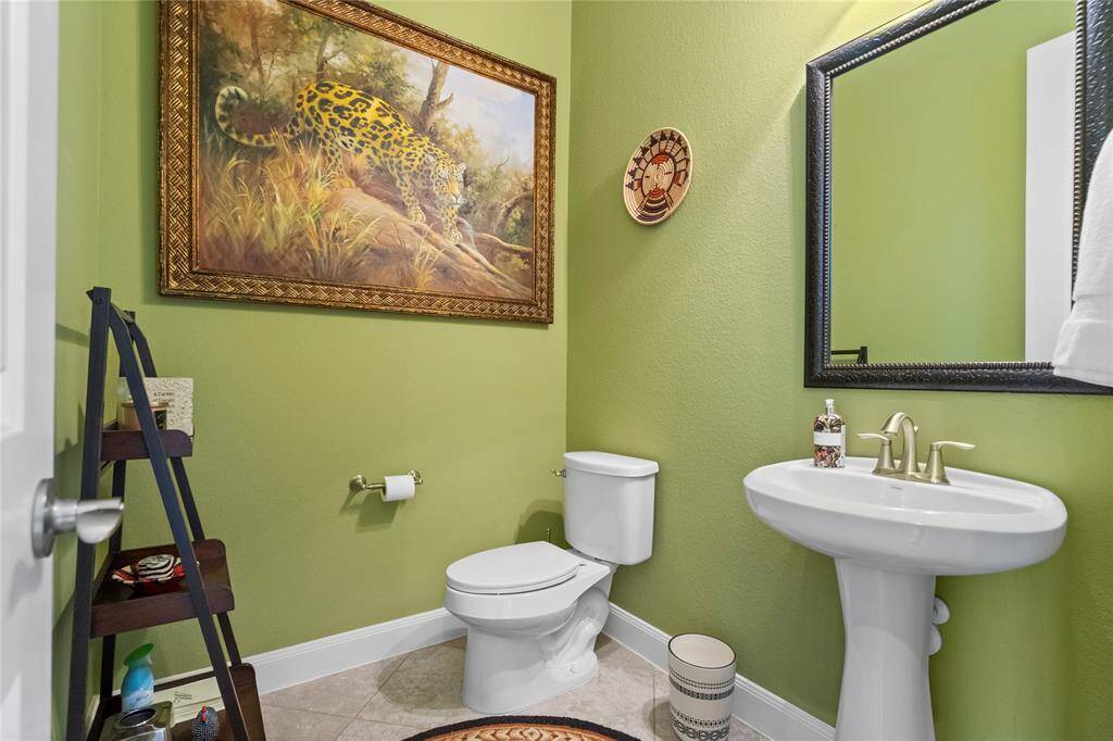 This is a cozy, well-lit half bathroom with green walls.