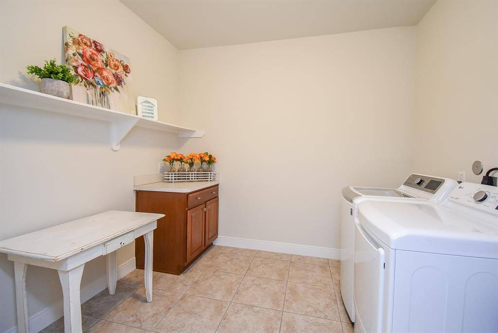 Look at all the space in this laundry room! It features an added sink for handwashing, extra shelving for organization, and plenty of room to accommodate an additional refrigerator or a large folding table—the possibilities are endless.