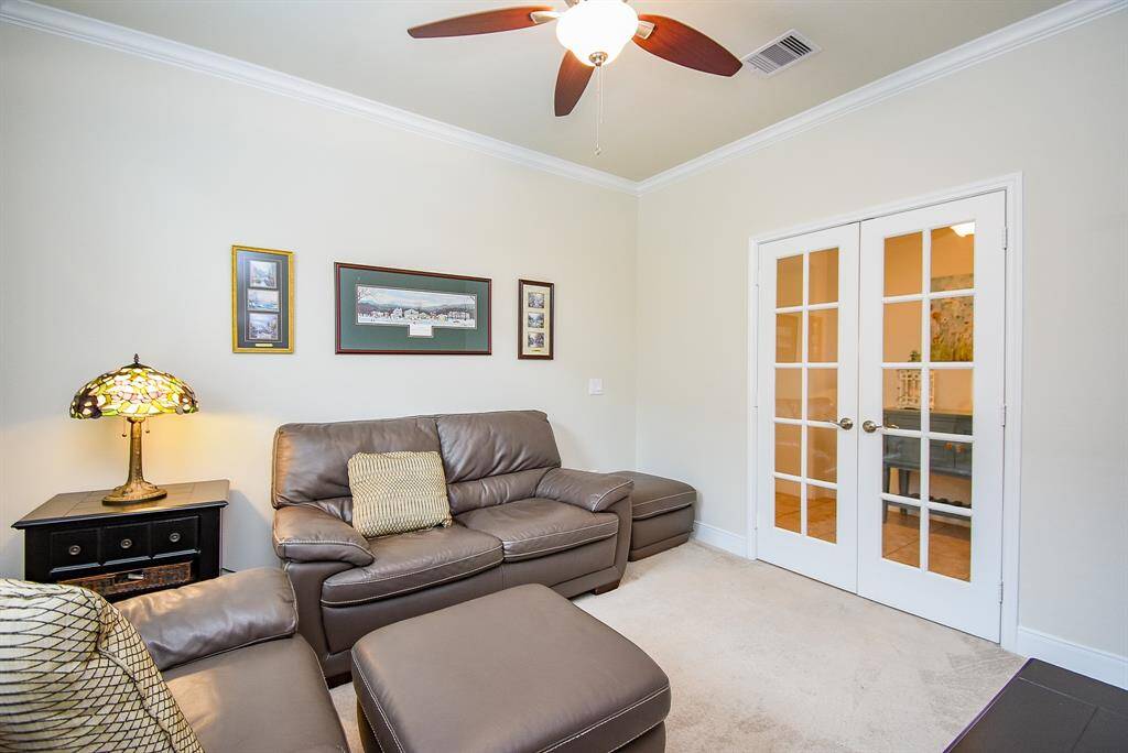 This spacious room offers endless possibilities—use it as a home office, exercise space, or cozy reading nook. It features an added ceiling fan for comfort, along with elegant crown molding that extends throughout most of the home for a refined touch.