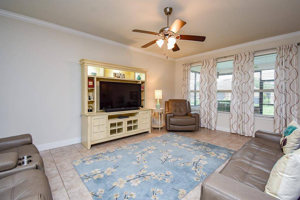 Welcome to your spacious family room, where comfort meets style. Enjoy the added ceiling fan, detailed crown molding, and abundant natural light streaming through large windows with a beautiful view. Step outside to the newly added covered patio, complete with removable windows—perfect for enjoying a refreshing breeze year-round.