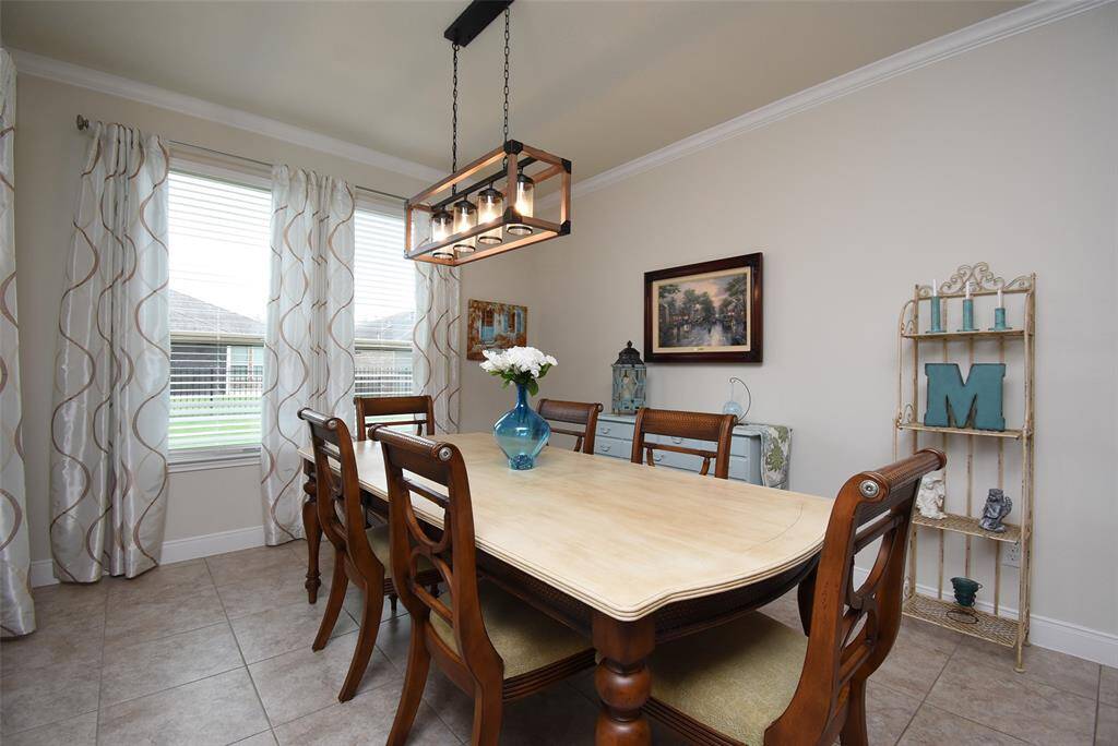 This view highlights the picturesque windows, the stunning light fixture, and truly showcases just how spacious this area is. Ready for dinner? This space is perfect for hosting meals and making memories.