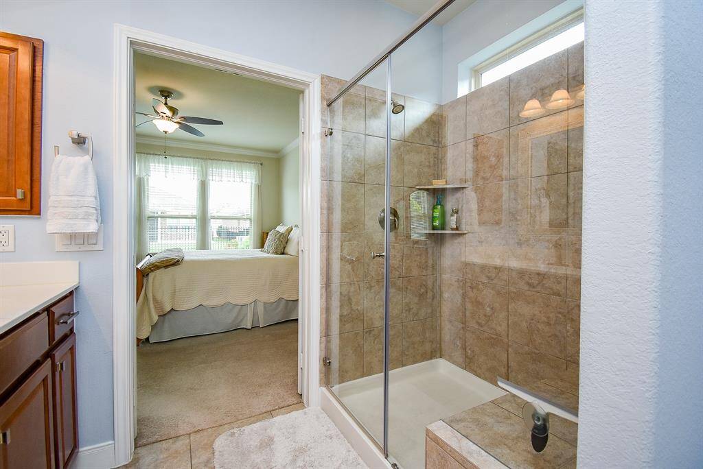 Enjoy the comfort of a large walk-in shower with ample space, offering both functionality and a spa-like feel. Not shown in the photo is a spacious storage closet and a private enclosed toilet room, adding both convenience and privacy to the space.