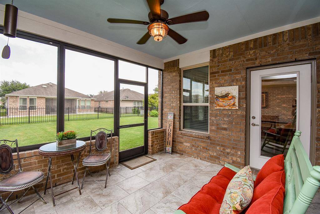 Welcome to your screened-in porch—a perfect blend of comfort and style. The seller thoughtfully added removable windows to let the breeze flow through, along with a ceiling fan for added comfort. Extended brickwork adds a modern, upscale touch, beautifully complemented by the stone flooring. It's the ideal spot to enjoy your morning coffee, relax with a good book, or play cards with friends.