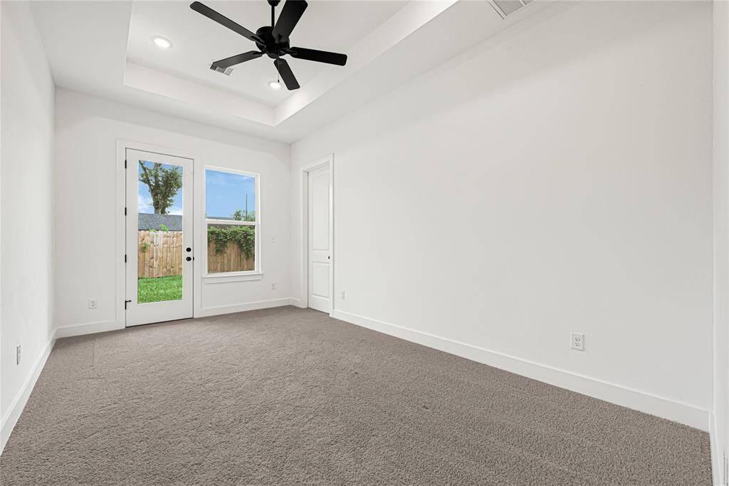 Primary bedroom with celling fan and trey cellings.