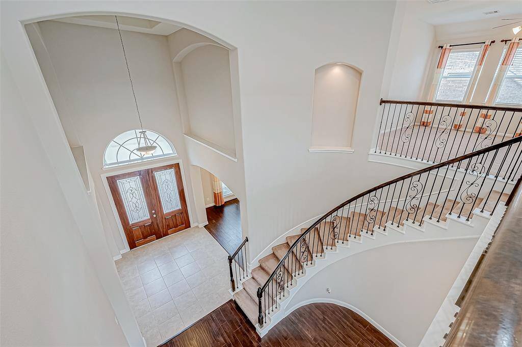 The beautiful curved staircase leads to the upstairs area.