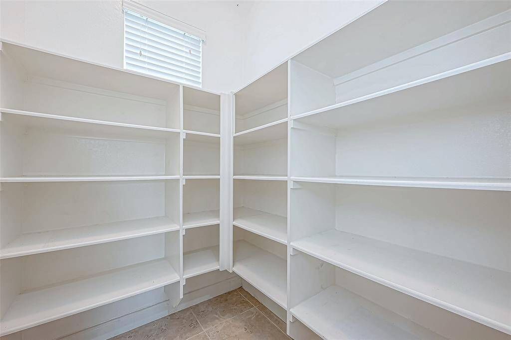 The pantry room offers ample storage space with well-organized shelves, providing plenty of room to keep your kitchen essentials neatly arranged and easily accessible.