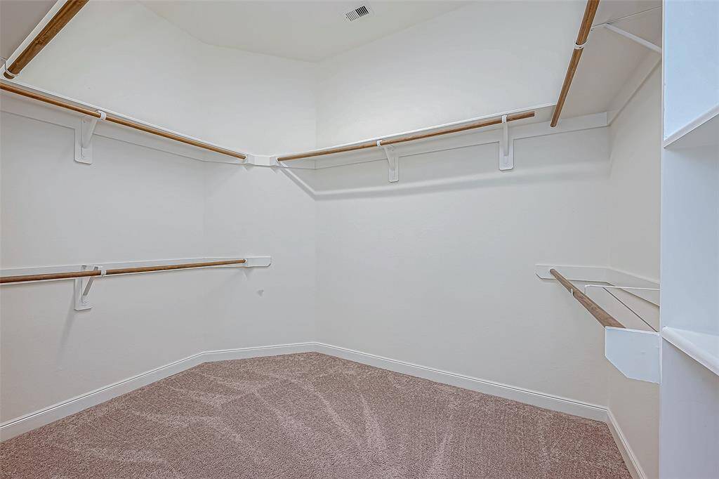The closet is spacious and features built-in shelves, offering plenty of organized storage space for your belongings.