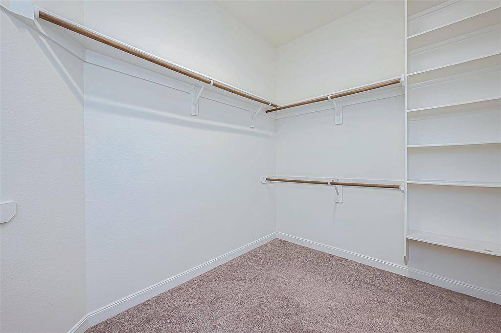The closet is spacious and features built-in shelves, offering plenty of organized storage space for your belongings.