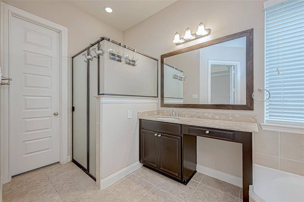 The master bathroom features a double sink vanity, offering plenty of space for shared use. It also includes a separate bathtub and shower.
