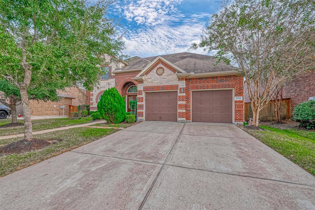 The front of this home features a spacious two-car garage and a long driveway with room for up to four additional vehicles. Perfect for hosting family gatherings or parties, this setup offers both convenience and ample parking space.