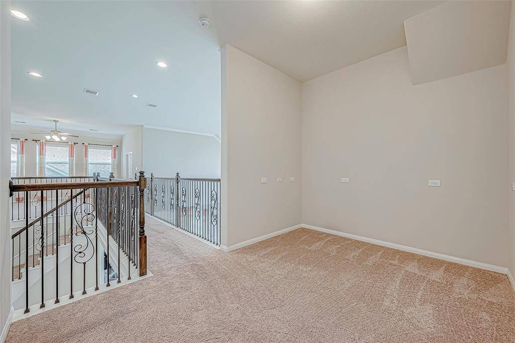 Upstairs, a long walkway leads to a game room or common area, along with several bedrooms. This layout creates a functional and spacious area, perfect for family activities and relaxation.