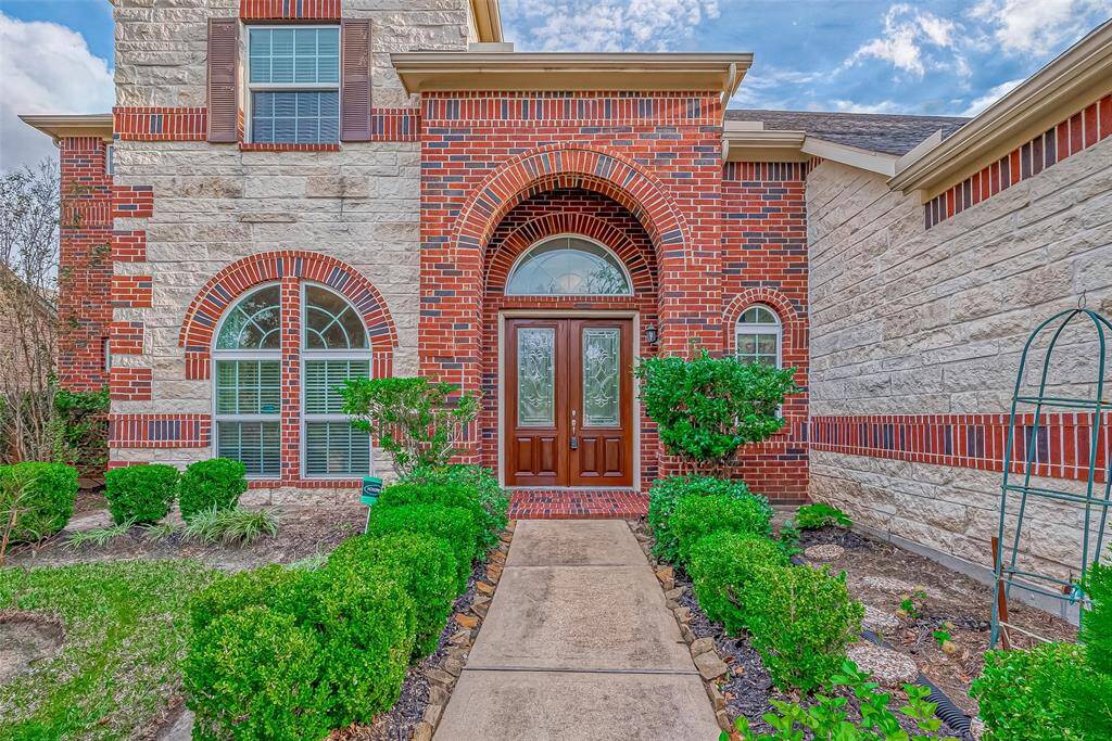 The elegant wooden front door welcomes you with warmth and charm, setting the tone for the inviting interior of this beautiful home.