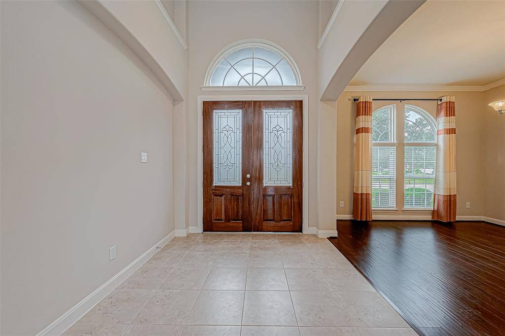 The view from inside features the front door with tiled flooring, beside is the formal dining room conveniently located just beside the entryway.