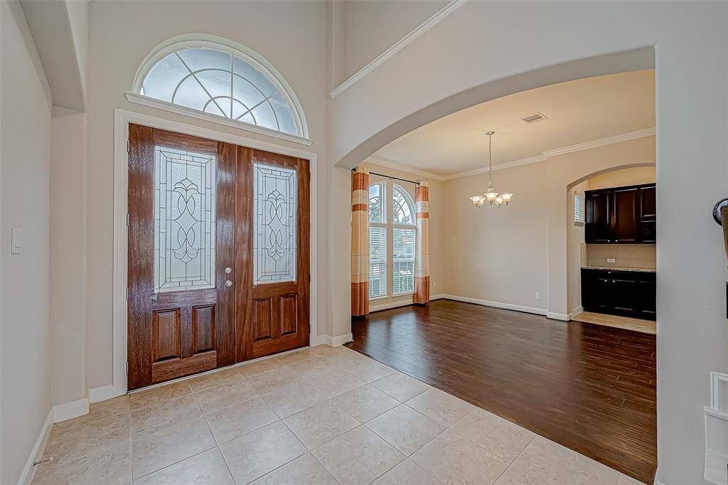 This formal dining area features elegant lighting and beautiful wood flooring, creating a warm and inviting space for gatherings.