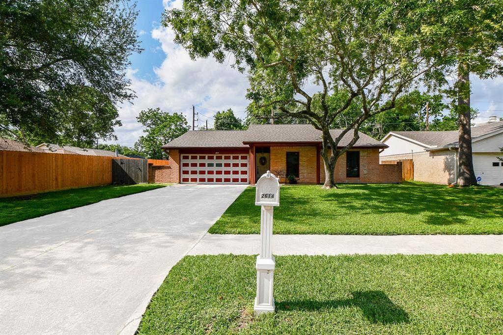 Home Features a long driveway leading to an oversized two-car garage. Located on a quiet street, offering privacy with a fenced backyard.
