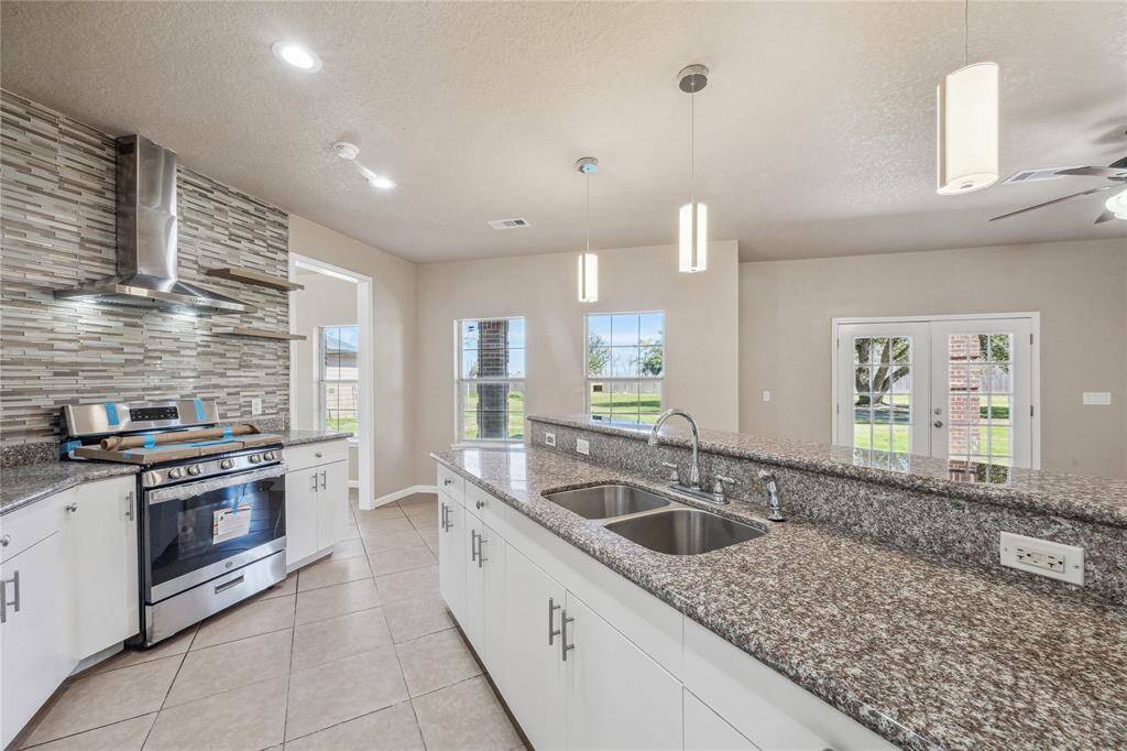 Discover the perfect blend of style and functionality in this kitchen featuring granite countertops, elegant finishes, and easy-to-clean ceramic tile flooring.