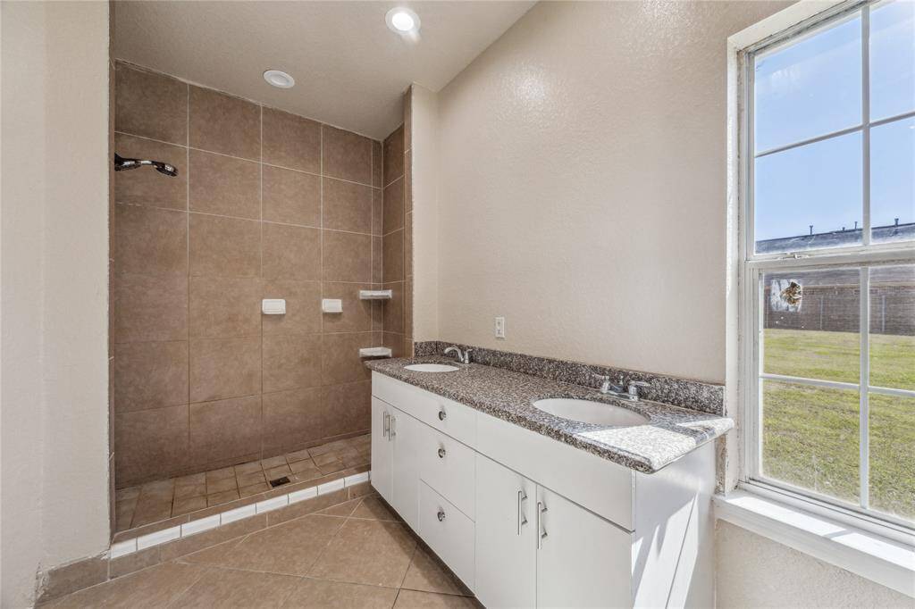 Experience luxury in the primary bathroom with dual sinks and a spacious shower.