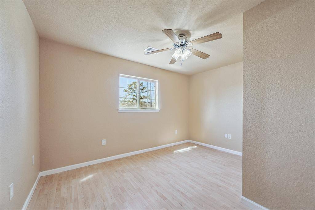 Charming upstairs bedroom with soft neutral tones and sleek laminate flooring.