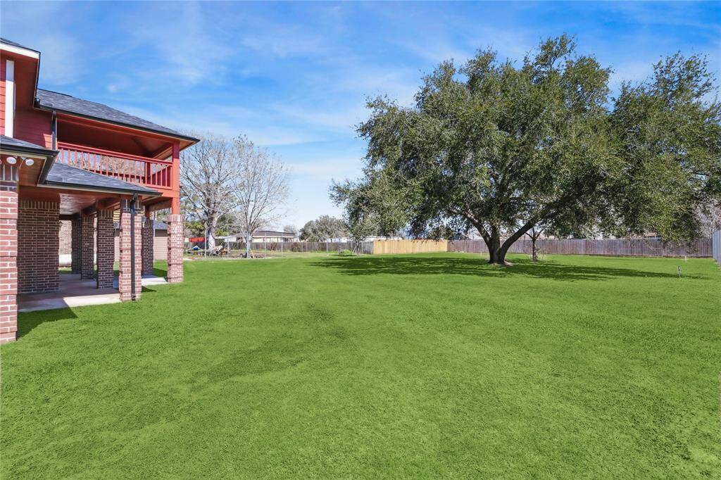 The majestic backyard tree offers ample shade, creating an ideal setting for gatherings.