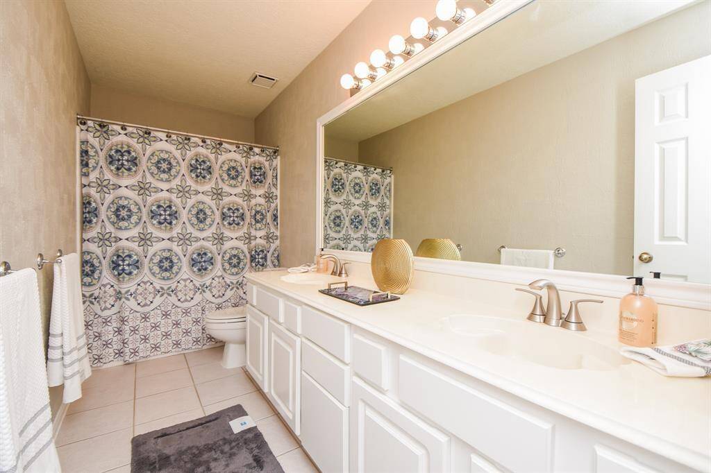 The full guest bathroom offers plenty of counter space and storage.
