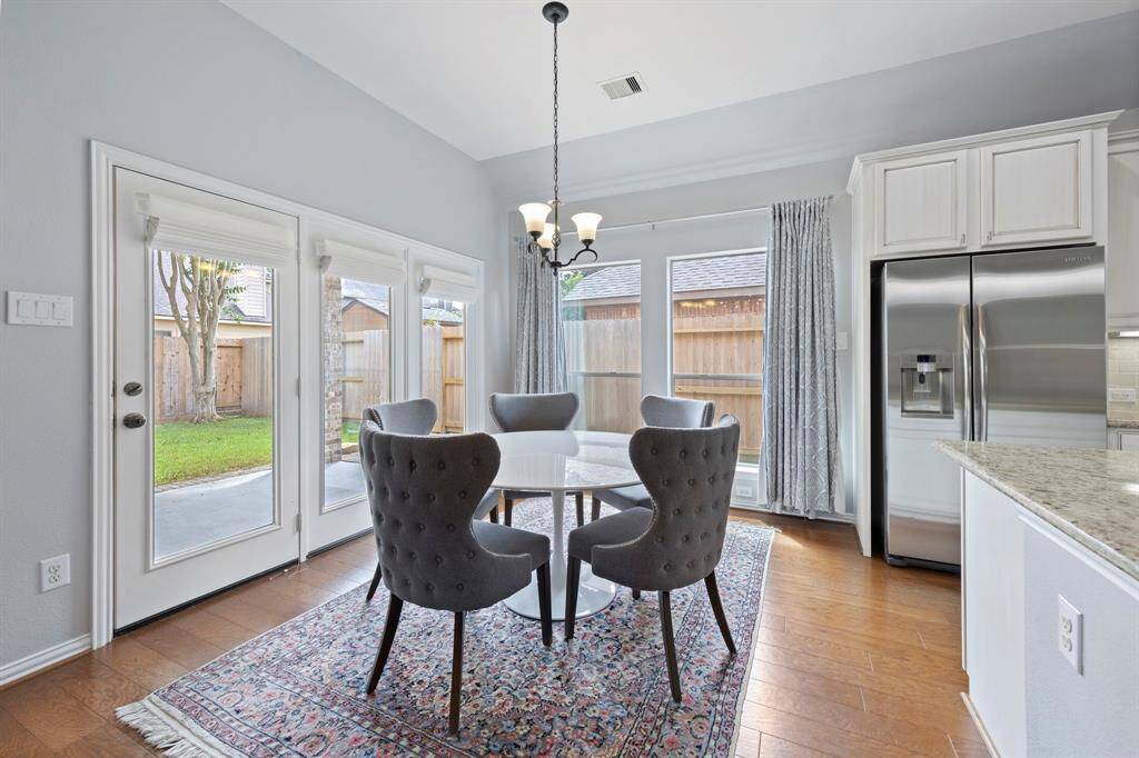 The cozy breakfast nook offers a charming space to enjoy casual meals, surrounded by expansive windows that bring the outdoors in.