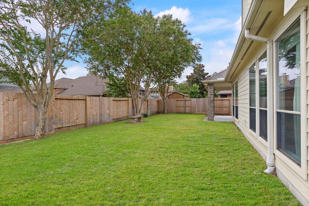 The spacious backyard offers lush green space, mature trees, and plenty of room to play, garden and room for a pool!
