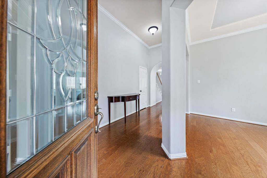 As you step through the front door, you're greeted by rich hardwood floors, neutral paint, and elegant crown molding, creating a warm and sophisticated first impression.
