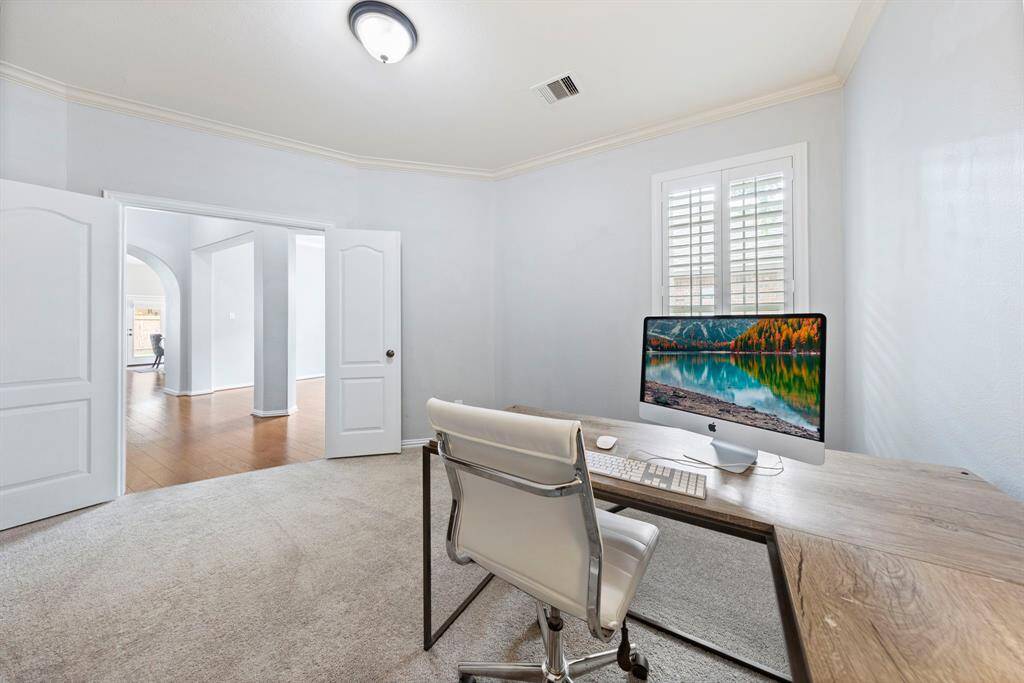 Just off the entry, double doors lead to a bright home office with plantation shutters and plush carpet—ideal for work or study.