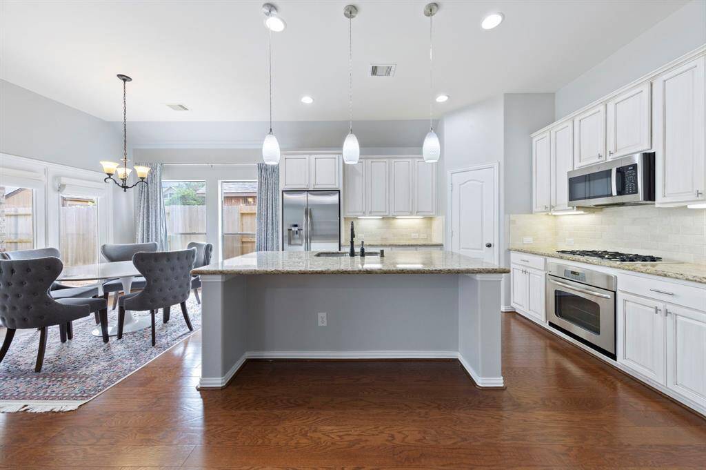 Large island with breakfast bar seating for casual dining and modern pendant lighting above.