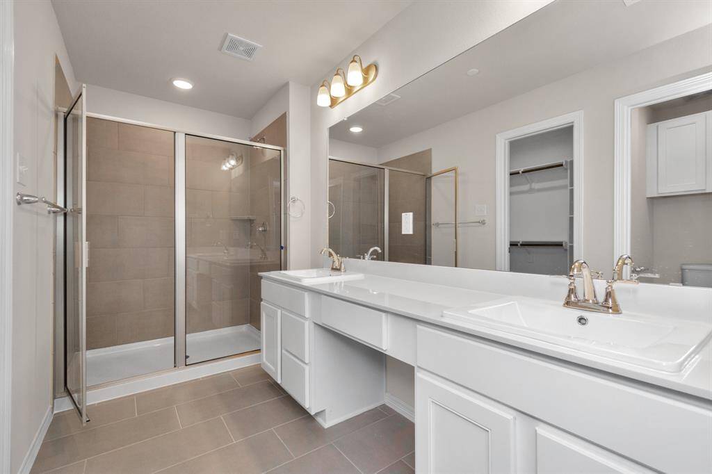 Luxurious bathroom with oversized shower and dual sinks.
