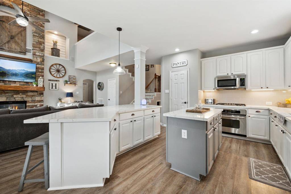 What a chef's delight - perfect work triangle! Gleaming quartz countertops, extra quiet Bosche dishwasher, FIVE burner gas range, complete with an island prep area!