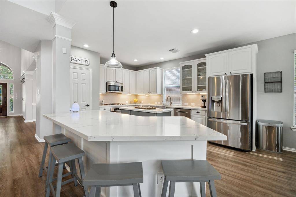 Notice the under cabinet lighting, white cabinets, and again, that incredible quartz countertop!