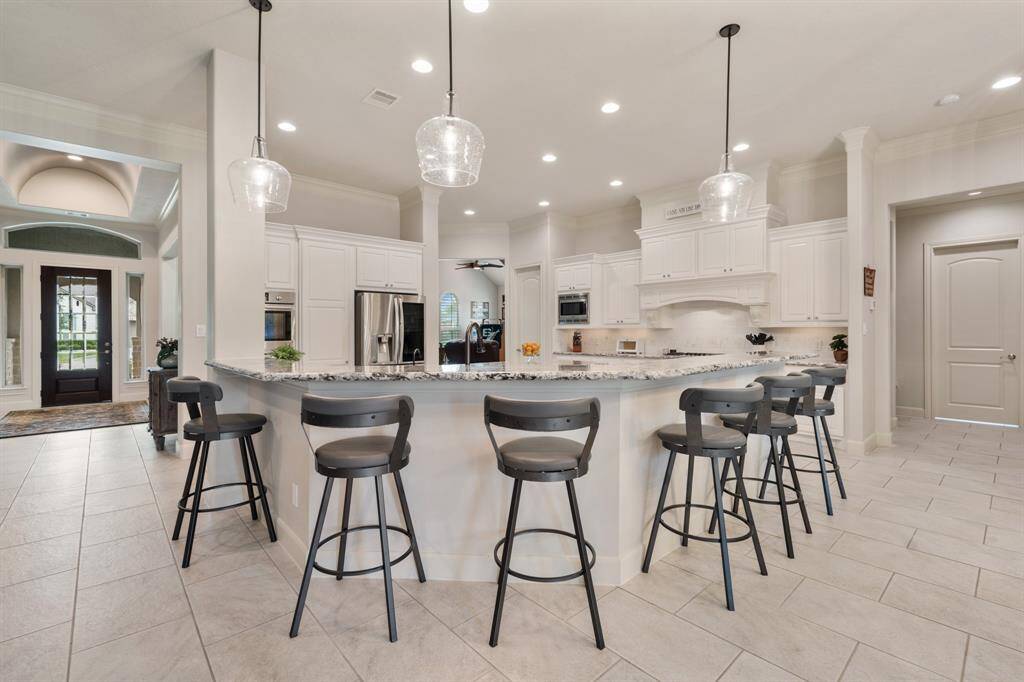 This wrap around bar can easily provide eight additional seats. Three new pendant lights keep the space light and bright. This is the perfect place to grab a quick breakfast, decorate cookies, or even tackle daily homework.