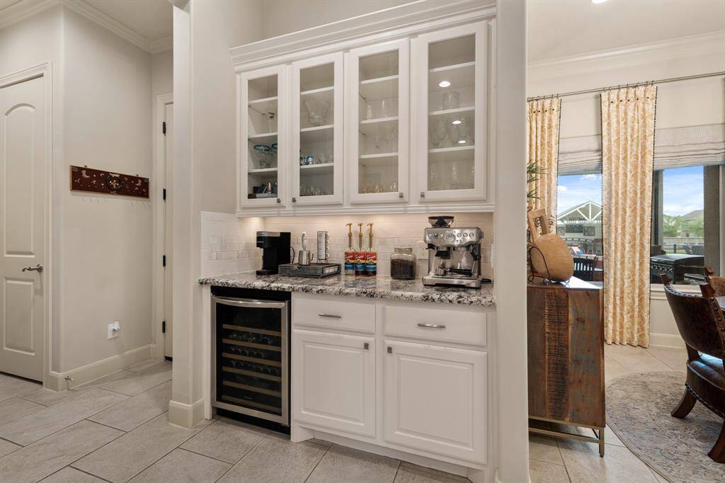 This Butlers Pantry provides a beverage station, wine fridge, and both open and closed storage. This is the perfect spot to store glassware and formal dishes.