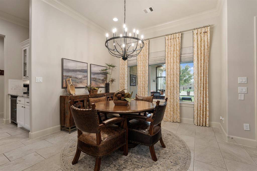 This spacious Breakfast Room boasts a trio of picture windows, adorned with custom curtains, overlooking the Porch and Pool. A new chandelier adds just the right amount of flair and sophistication to the more casual space.