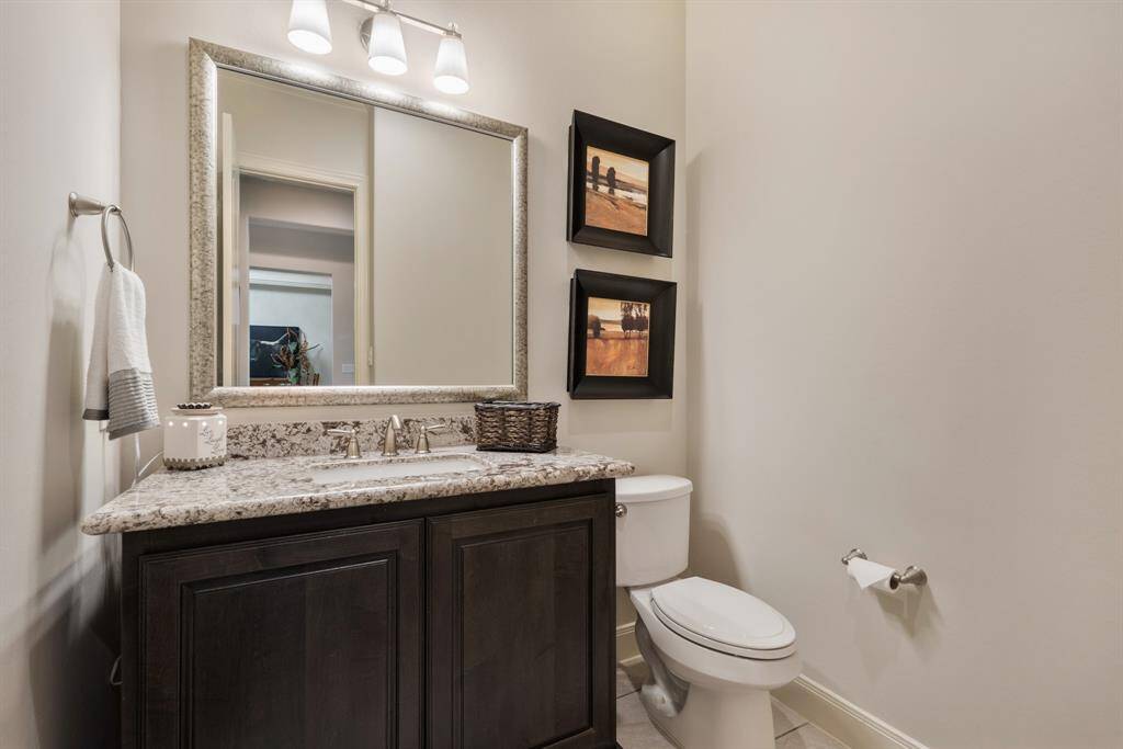 Located off the Foyer, and easily accessible to guests, this Powder Room boasts granite countertops, an undermount sink, and framed mirror.