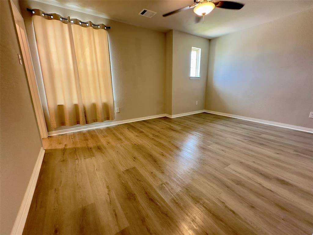 Spacious fifth bedroom with natural light and modern flooring—perfect for guests or a home office.