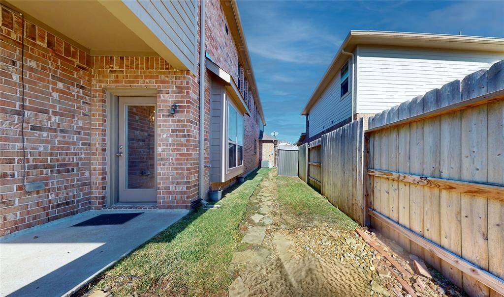Charming side yard with cozy seating area, perfect for relaxation and outdoor gatherings.